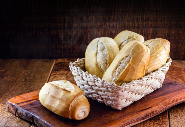 several traditional breads from brazil, on a rustic wooden background in a straw basket. National day of Brazilian French bread.